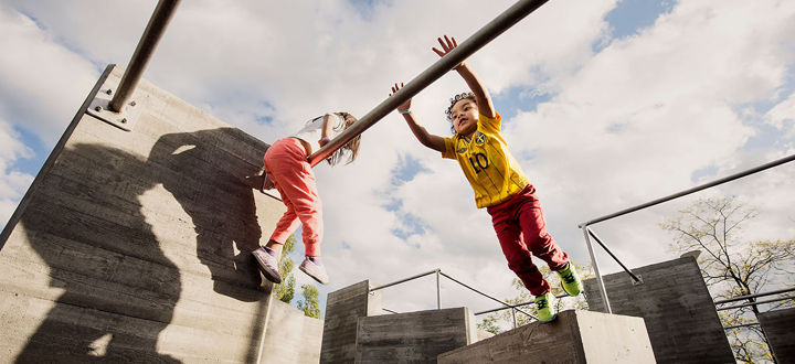 Barn som leker i parkourparken i Södertälje. Barnen bär färgglada kläder. 