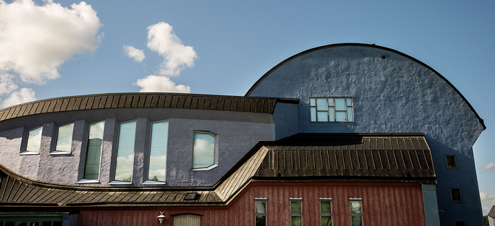 Järna kulturhus på bild. Det är en färgglad byggnad i Järna som på bilden har en blå himmel som bakgrund. 